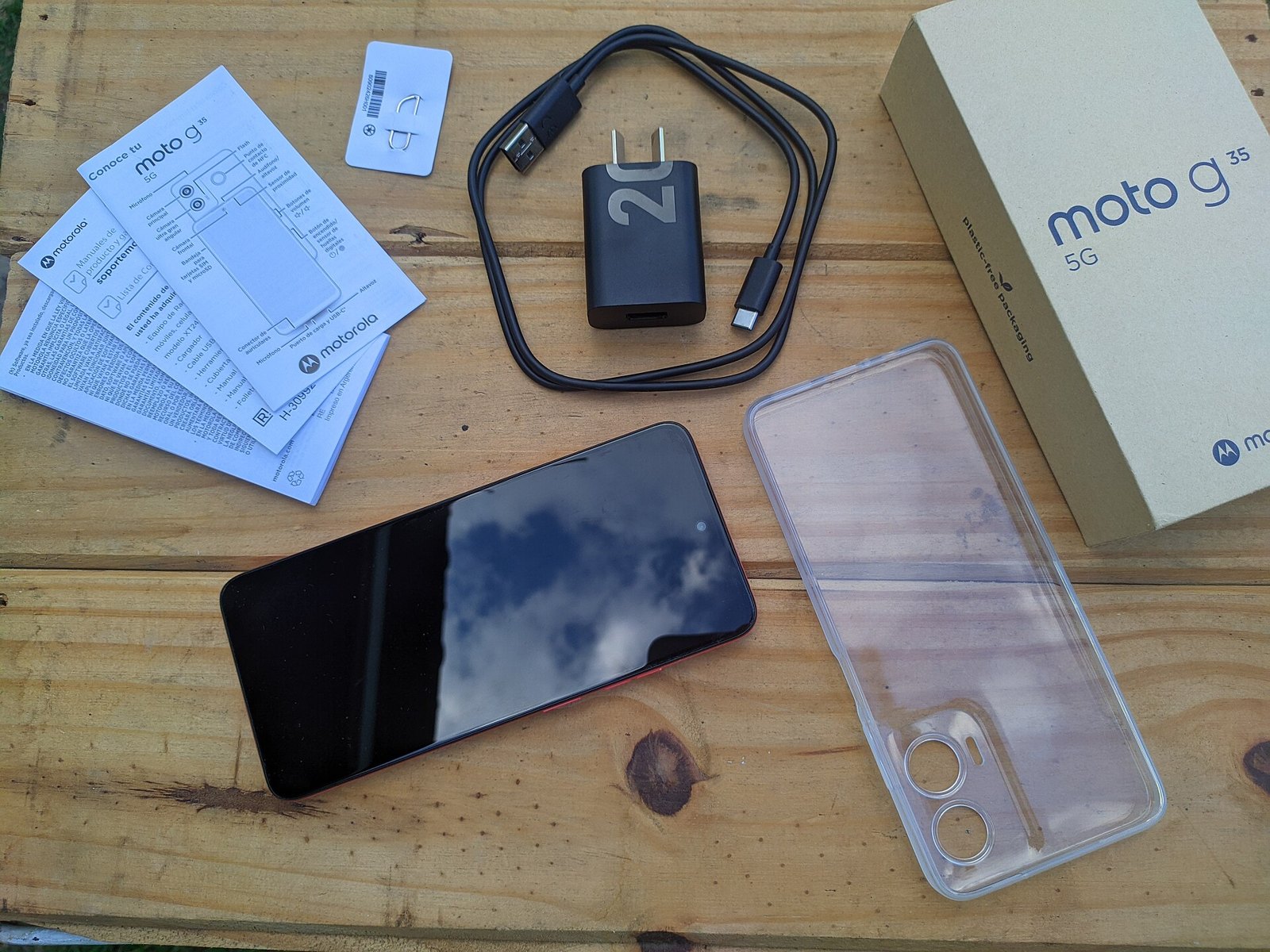 Kutusundan çıkarılmış akıllı telefon, şarj aleti, kablo ve kılıf