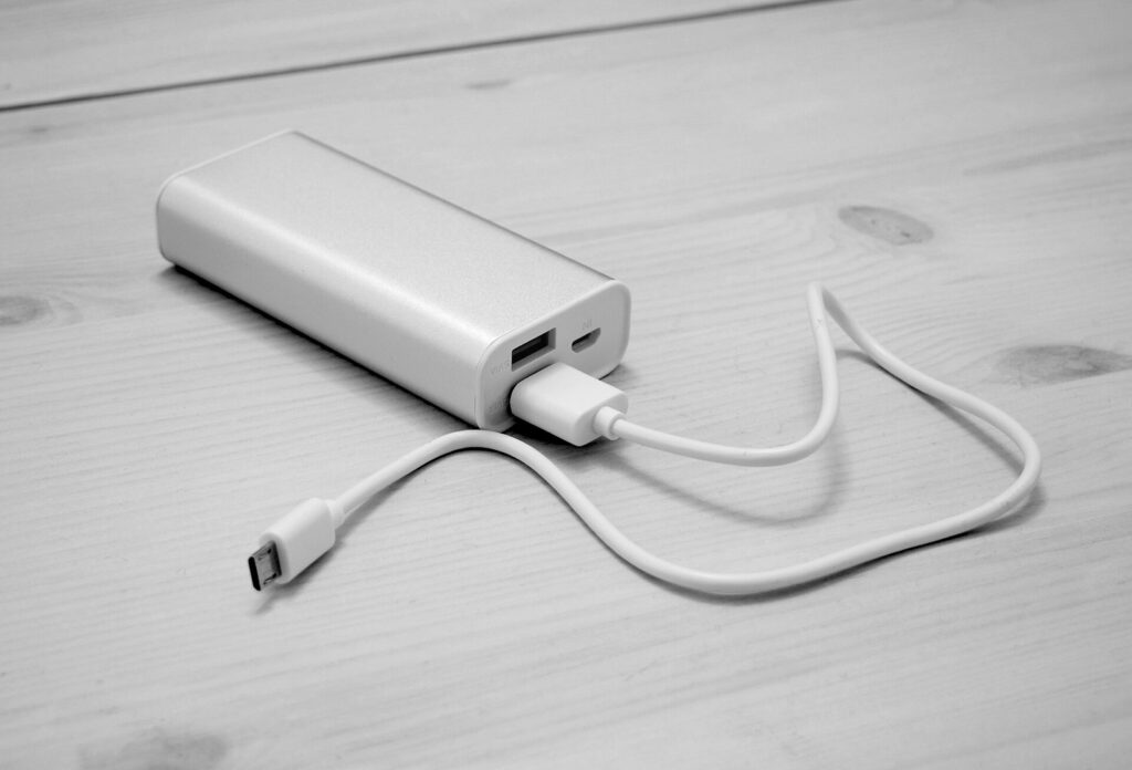 Masa üzerinde USB kabloya bağlı beyaz taşınabilir şarj cihazı