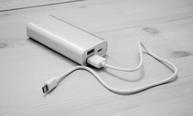 Masa üzerinde USB kabloya bağlı beyaz taşınabilir şarj cihazı