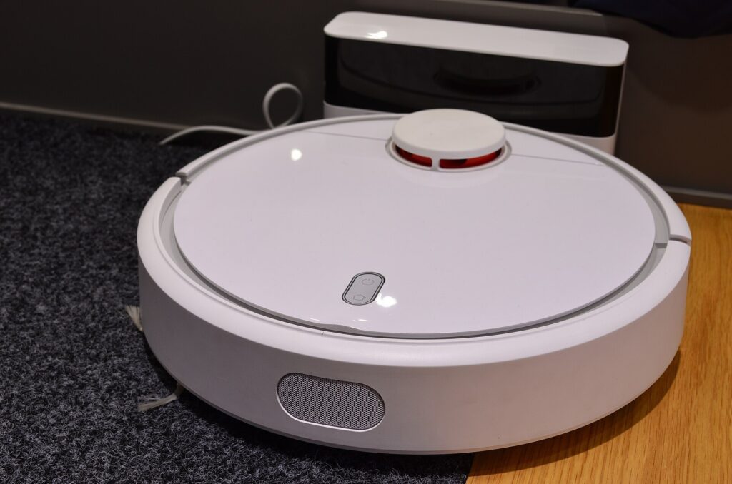 Üstünde LiDAR sensör kulesi bulunan beyaz robot süpürge